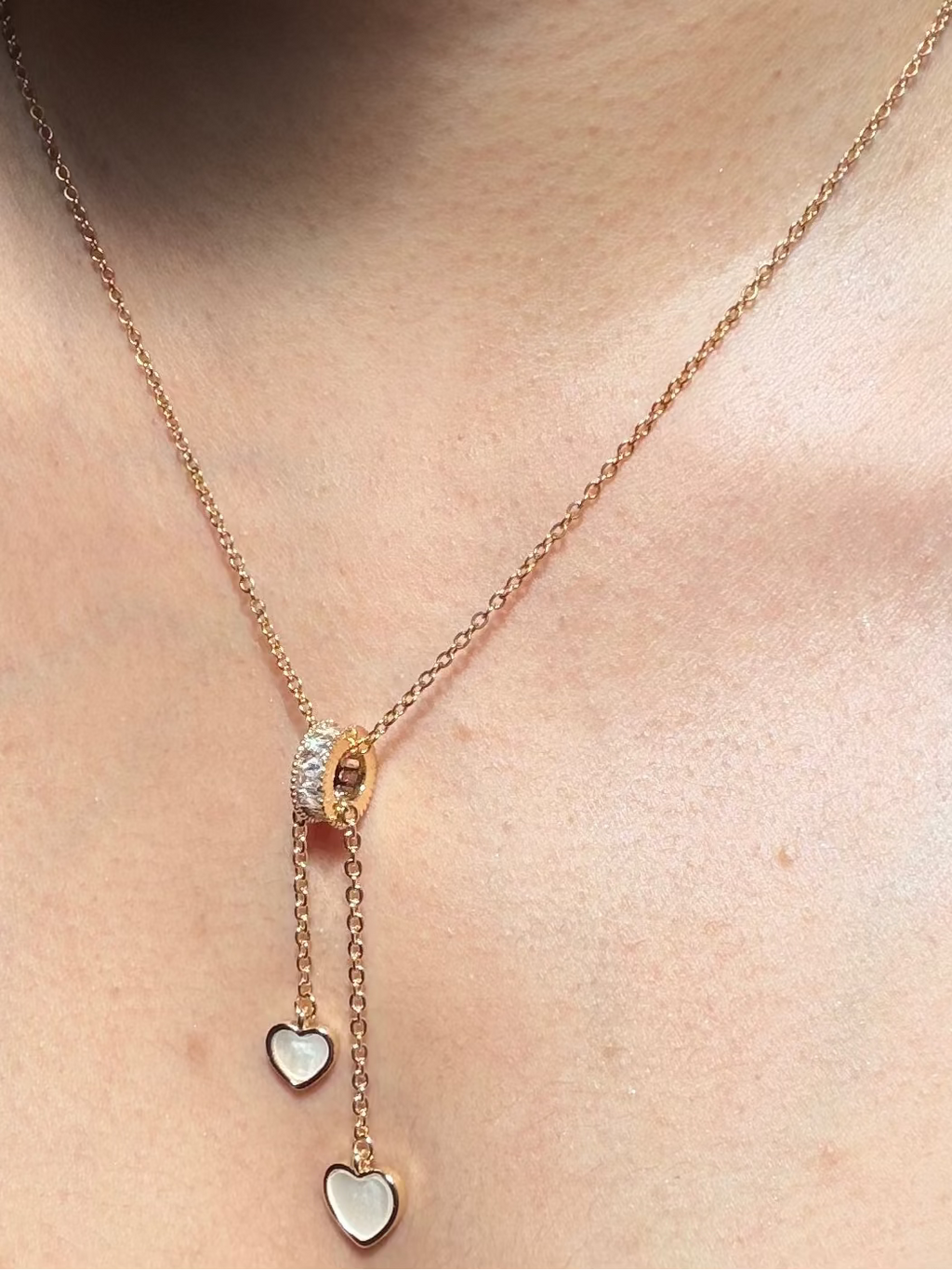 Necklace with heart-shaped pendants worn by a person 