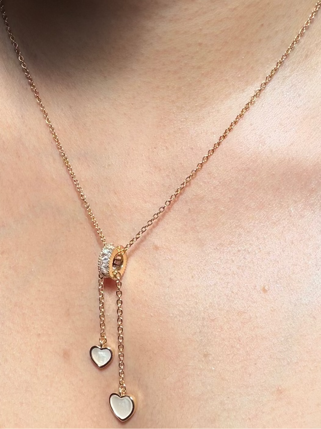 Necklace with heart-shaped pendants worn by a person 